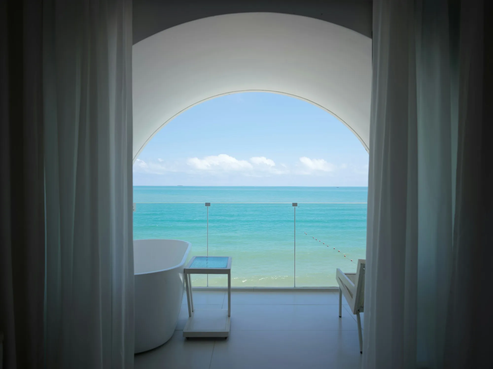 La vasca da bagno davanti a una finestra ad arco sul mare turchese